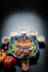 Traditional Italian food, Sliced grilled beef and organic vegetable salad with salad dressing on wooden plate have an appetizer dining in restaurant.