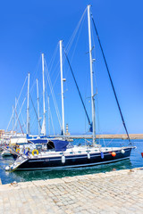 Fototapeta premium Yachts with lowered sails on the pier in the bay of the Mediterranean city
