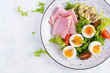 Ketogenic/paleo diet. Boiled eggs, ham, avocado and fresh salad.  Keto breakfast. Brunch.  Top view, overhead