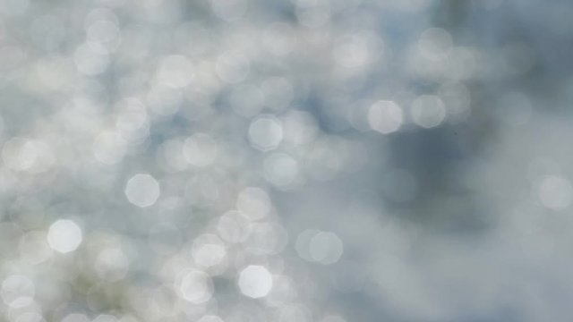 blurred blue river rapids shine at bright sunlight in bokeh background closeup slow motion
