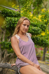 The girl posing in the tropical garden with palms