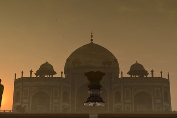 A reflection in water and mesmerizing view of humayun tomb memorial from the main gate,entrance at winter foggy morning.