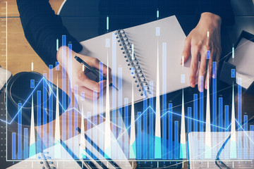 Forex graph on hand taking notes background. Concept of research. Multi exposure