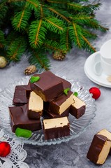 Homemade candy Birds milk with chocolate glaze and caramel souffle (mousse) on a gray background. Traditional Russian holiday dessert. Vertical orientation.
