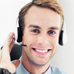 Face portrait of happy smiling support phone male operator or sales agent in headset, confident...