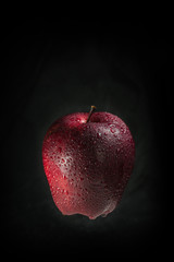 A red apple on a black background.