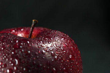 A red apple on a black background.
