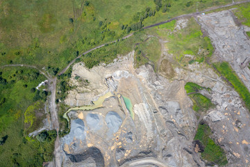 Aerial view of a small plant for the production and cleaning rubble and cement near the heaps of building materials, the tractors and excavator. Mining in quarry.