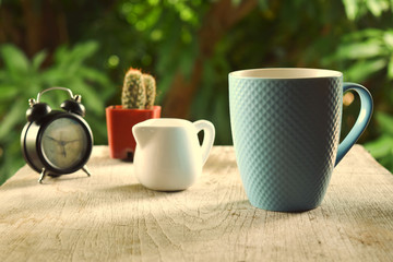 Beautiful blue ceramic coffee mug image Placed on an old wooden table With a beautiful natural background in the morning