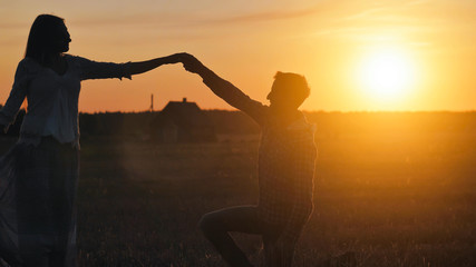 Silhouettes of a dancing couple in love at sunset.