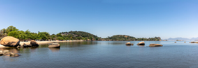 Panorama of Jose Bonifacio Beach, with rocks in the corner, cloudless blue sky, Paqueta, Rio de Janeiro, Brazil