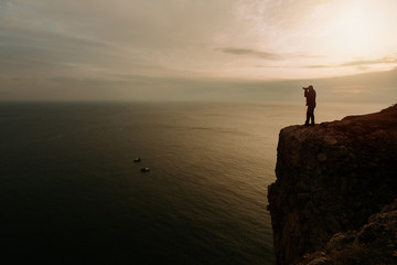  silhouette of the photographer on a rock in the sea