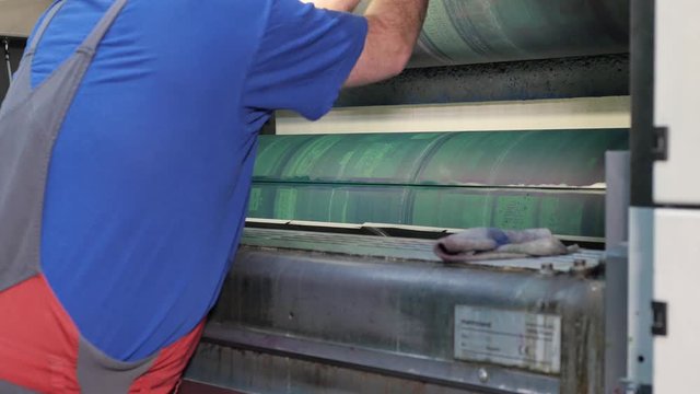 Worker takes off printing plates in press factory