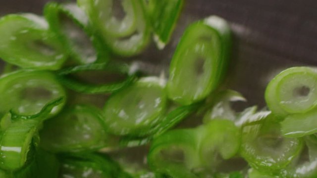 Chopping green onion macro shot, cooking process, tasty and vibrant image, sharp knife, cutting a spring onion, slow motion, shot on Red Weapon Helium