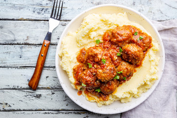 Meatballs in tomato sauce with mashed potato on the white plate, top view, view from above