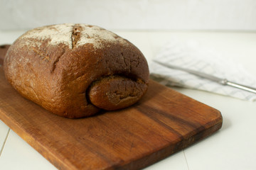 Freshly baked bread on a cutting board on a white background