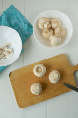Champignon slices on a wooden board, preparing mushrooms for further cooking