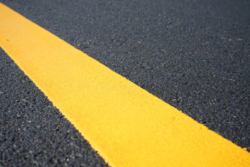 Fototapeta premium Yellow traffic paint lines during construction phase, blurred pictures