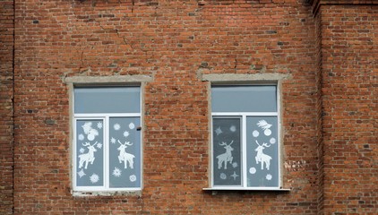 Windows of  old red brick building. Christmas decor on the glass
