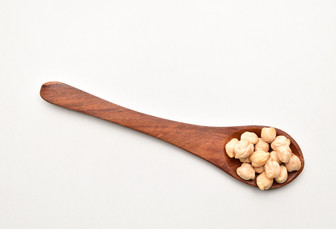 chickpeas in wooden spoon isolated on white background