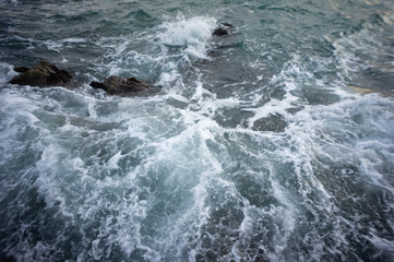 Sea waves are breaking on stones. Sea foam