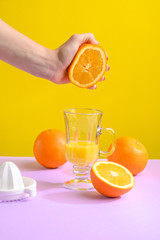 Female hand holding crushes orange and juice.