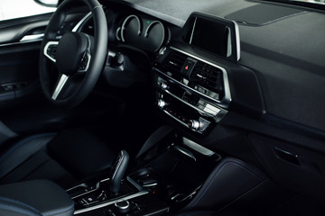 Fototapeta na wymiar Business car interior. Interior of prestige modern car. Front seats with steering wheel, dashboard & display. 