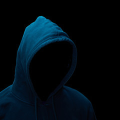 Gefährlicher Hacker mit Kapuzenpullover vor schwarzem Hintergrund.