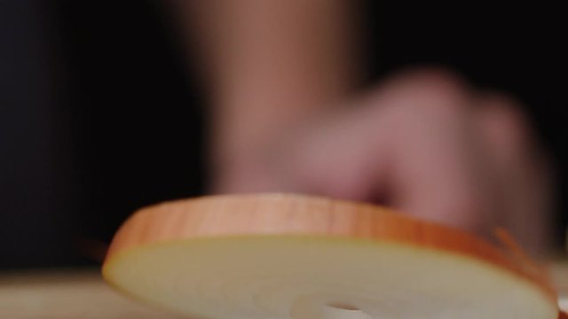 Slice of onion falls and breaks on rings macro shot, sliced onion, making salad, isolated, slow motion, shot on Red Weapon Helium 8k