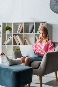 Injured Woman Working From Home With Laptop