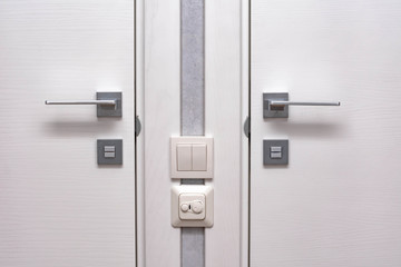 Modern chrome door handle and lock on white wooden door.