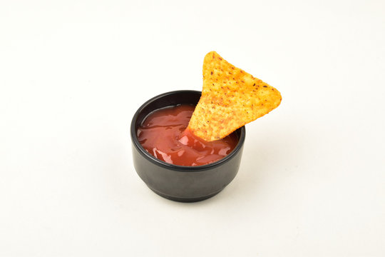 Single Nacho Chip Dipped In Sauce Over White Background