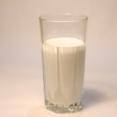Glass and white milk inside the glass on a white background side view