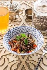Asian Sliced Beef Salad with pepper and Carrots on oriental wooden table