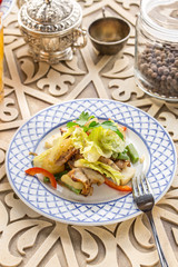 Grilled chicken salad with pepper and green beans on oriental wooden table