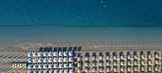 Aerial drone top view photo of beautiful organised Mediterranean deep turquoise sandy beach