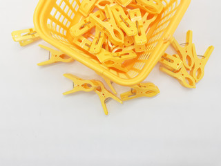 Orange Bright Colorful Stylish Clothing Clip Pegs for Hanger Rod Drying Room Appliances with Mesh Basket Packaging Container in White Isolated Background