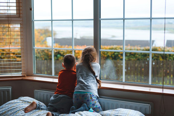 children looking through window together
