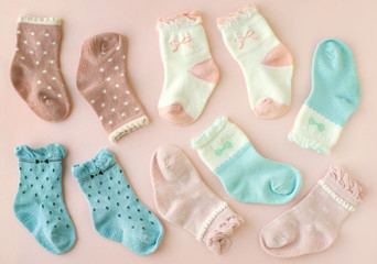 Socks for children on a pink background. Many socks made of soft knitwear on a pink background. Children's clothing in the form of socks.
