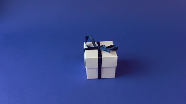Blue gift box with bow in female's hand