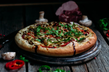 Pizza with ham, mushrooms and cheese on the table