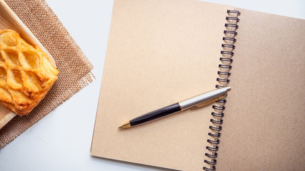 Pineapple Pie Bakery  with Brown book  and pen  put on white background, have copy space.