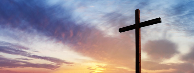 Cross of Jesus Christ over dramatic sunrise sky panorama with sclouds.  Easter concept
