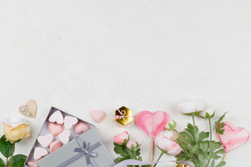 white and pink candy in form of hearts in box , flowers, decoration, gifts and ribbon on white background.