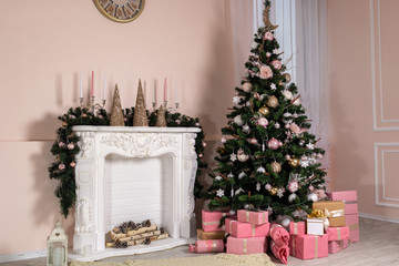 Christmas tree with a lot of gifts in the room near the fireplace.