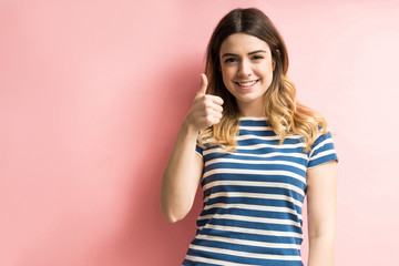 Fototapeta premium Confident Woman Showing Thumbs Up In Studio