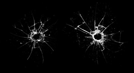 hole in the glass with cracks isolated on a black background - obrazy, fototapety, plakaty