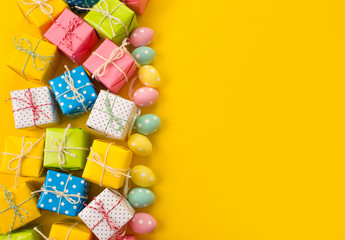 Easter holiday background. Pastel coloured decorated easter eggs on a bright yellow background