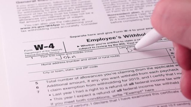 Tax reporting. Human fills out the W-4 tax form