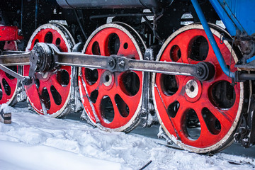 New Year's steam engine in the winter. Close-up of an old snow-covered steam locomotive. New Year Railway